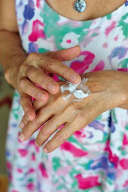 Manos femeninas  aplicando crema para manos